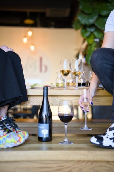Close-up of wine glasses and bottle at Princess & Bear Wines event.